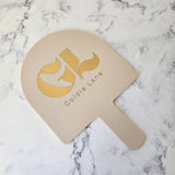 Arch Handheld Mirror Almond Acrylic and Gold Logo