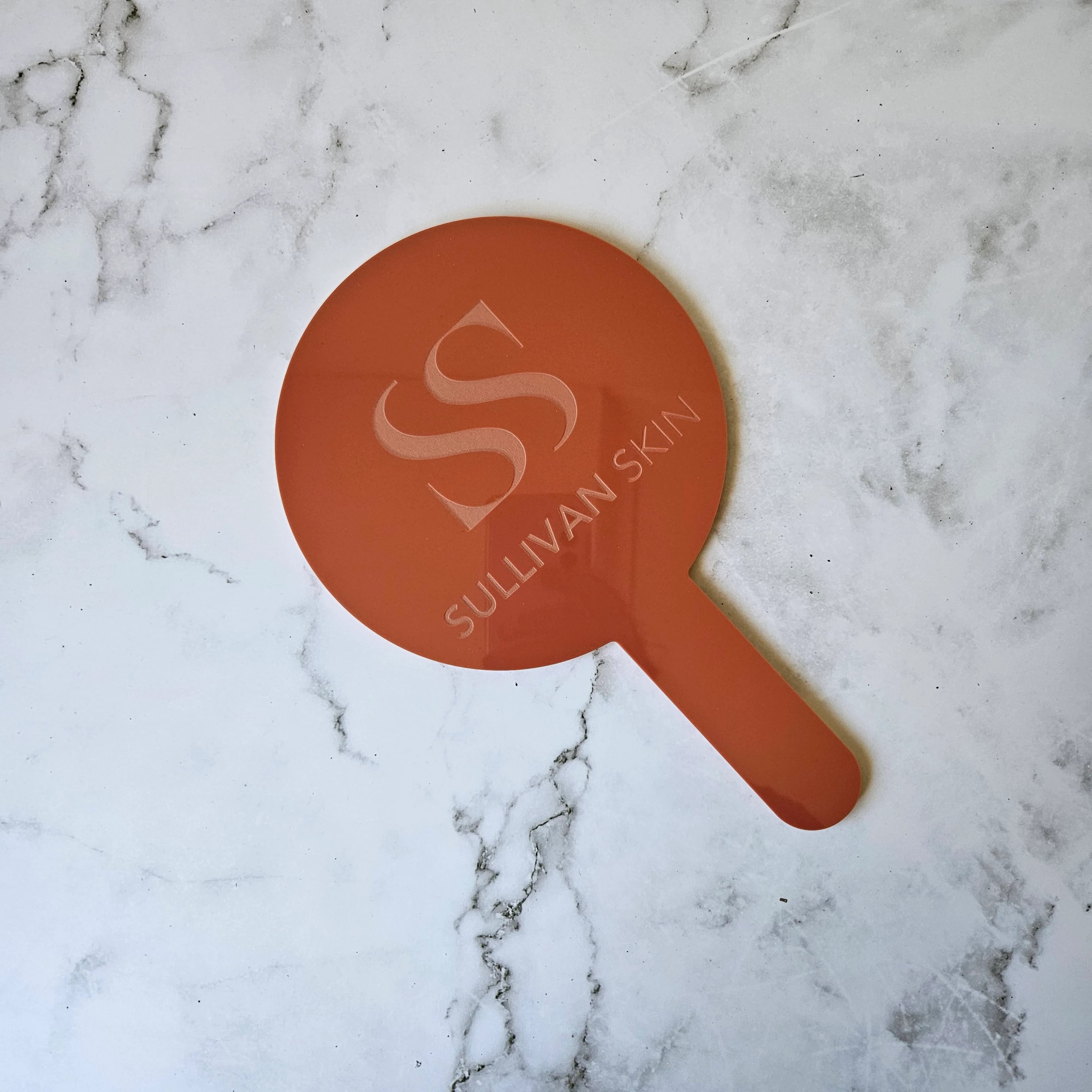 Round Handheld Mirror in Terracotta Red (Gloss) Acrylic and engraved logo